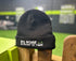 Black beanie with stitched no nose in front of toes logo sitting on a wooden gate | The Dog Therapist