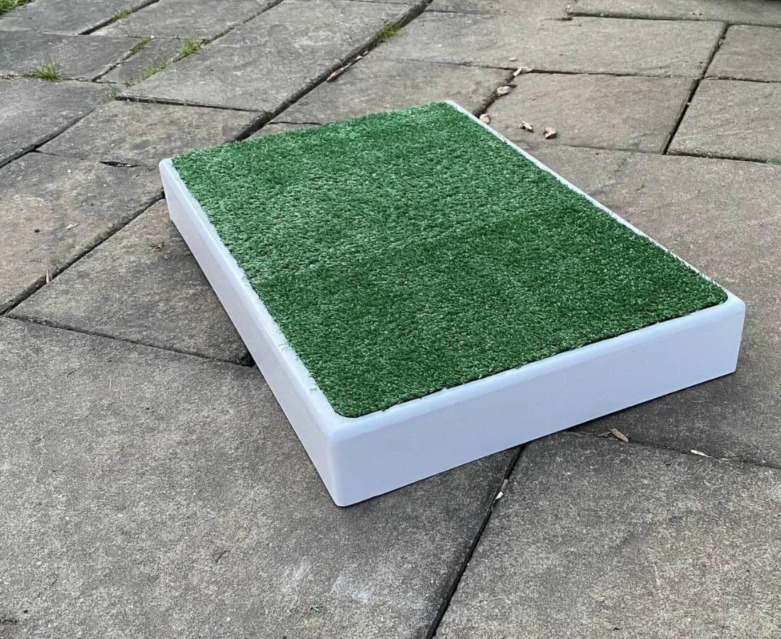 A white plastic place board with artificial grass top | The Dog Therapist